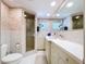 Bathroom showcasing white tile, a glass-enclosed shower, and a vanity with ample countertop space at 10111 Glen Moor Ln, Port Richey, FL 34668