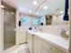 Bathroom showcasing white tile, a glass-enclosed shower, and a vanity with ample countertop space at 10111 Glen Moor Ln, Port Richey, FL 34668