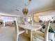 Formal dining area showcasing ornate decor, chandelier, and seamless flow to living room at 10111 Glen Moor Ln, Port Richey, FL 34668