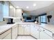 Well-lit kitchen features lots of countertop space, white cabinets, and an adjacent living area at 10111 Glen Moor Ln, Port Richey, FL 34668