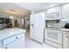 Well-lit kitchen with white appliances including a refrigerator, oven, and microwave at 10111 Glen Moor Ln, Port Richey, FL 34668