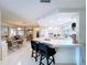 Open kitchen and dining area featuring a breakfast bar, white cabinetry, and tile flooring at 10111 Glen Moor Ln, Port Richey, FL 34668