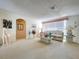 Spacious living room with plush carpet, neutral decor, and ample natural light, perfect for relaxation at 10111 Glen Moor Ln, Port Richey, FL 34668