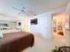 This main bedroom features a ceiling fan, TV, and views of other rooms through an adjoining doorway at 10111 Glen Moor Ln, Port Richey, FL 34668