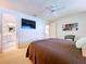 This main bedroom has a ceiling fan, TV, and a bathroom with a view of the vanity and sink at 10111 Glen Moor Ln, Port Richey, FL 34668