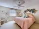 Main bedroom with a ceiling fan, large windows, and a decorative floral arrangement at 10111 Glen Moor Ln, Port Richey, FL 34668