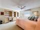 Main bedroom with a ceiling fan, built-in shelving, and large windows with blinds at 10111 Glen Moor Ln, Port Richey, FL 34668
