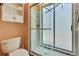 A bathroom features a toilet, walk-in shower with glass door, and built-in shelf at 10155 Duffy Cir, Weeki Wachee, FL 34613