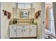 A bathroom features a vanity with white cabinets and sink plus decorative wallpaper at 10155 Duffy Cir, Weeki Wachee, FL 34613