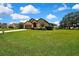 Charming single-story home featuring a well-manicured lawn and beautiful mature trees in the yard at 10155 Duffy Cir, Weeki Wachee, FL 34613