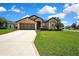 Lovely single Gathering home featuring a spacious front yard with lush green grass and mature landscaping at 10155 Duffy Cir, Weeki Wachee, FL 34613