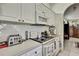 Galley kitchen with white cabinets, modern appliances, and an archway at 10155 Duffy Cir, Weeki Wachee, FL 34613