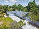 Aerial view showcases the home's charming exterior, long driveway, and well-maintained landscaping at 10301 Nina Ct, New Port Richey, FL 34654