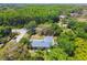 Aerial view of a gray house nestled among lush trees, backing up to a wooded area at 10301 Nina Ct, New Port Richey, FL 34654