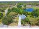 Aerial view of the property featuring a large pond and lush surrounding greenery at 10301 Nina Ct, New Port Richey, FL 34654