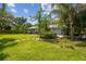 Expansive backyard with lush green lawn, mature trees, brick pathway and inviting outdoor space at 10301 Nina Ct, New Port Richey, FL 34654