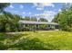 Large backyard with well-maintained lawn, mature trees and a patio area at 10301 Nina Ct, New Port Richey, FL 34654