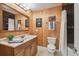Cozy bathroom with warm wood accents, a spacious vanity, tile floors, and a shower tub at 10301 Nina Ct, New Port Richey, FL 34654