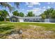 Charming single-story home featuring a large front yard, long driveway, and decorative privacy gate at 10301 Nina Ct, New Port Richey, FL 34654