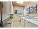 Bright laundry room with washer, dryer, granite countertop, storage cabinets and natural lighting at 10301 Nina Ct, New Port Richey, FL 34654