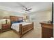 Spacious main bedroom boasts a large wood bed frame, ceiling fan, and ample natural light at 10301 Nina Ct, New Port Richey, FL 34654