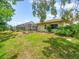 Spacious backyard with lush lawn, mature trees and the screened pool enclosure of the home at 10442 Ventura Dr, Spring Hill, FL 34608