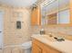 A well-maintained bathroom showcasing classic wallpaper, a wooden vanity, and a ceramic tiled floor at 10442 Ventura Dr, Spring Hill, FL 34608