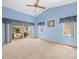 Comfortable bedroom with a ceiling fan, neutral carpet, and sliding glass doors to the backyard at 10442 Ventura Dr, Spring Hill, FL 34608