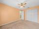 A bedroom with a ceiling fan, a double-door closet, and an open doorway to an adjoining bathroom at 10442 Ventura Dr, Spring Hill, FL 34608