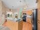 Open concept kitchen with wood cabinets, black appliances, island and seamless access to outdoor space at 10442 Ventura Dr, Spring Hill, FL 34608
