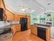 Kitchen with wooden cabinets, black appliances, breakfast bar, and seamless flow to the living area at 10442 Ventura Dr, Spring Hill, FL 34608