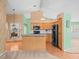 Bright kitchen with natural wood cabinets, granite counters, and modern appliances at 10442 Ventura Dr, Spring Hill, FL 34608