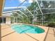 Inviting backyard pool with a screen enclosure, surrounded by lush landscaping and open sky at 10442 Ventura Dr, Spring Hill, FL 34608