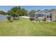 Landscaped backyard with a screened-in pool and a white picket fence for privacy at 1049 Larkin Rd, Spring Hill, FL 34608