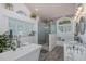 Bright bathroom features a soaking tub, glass shower, dual vanities, and plantation shutters at 1049 Larkin Rd, Spring Hill, FL 34608