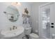 Well-lit bathroom features a sink, toilet, and door leading to the pool at 1049 Larkin Rd, Spring Hill, FL 34608