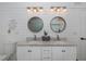Double vanity bathroom with round mirrors, marble countertop and white shiplap walls at 1049 Larkin Rd, Spring Hill, FL 34608
