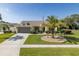 Charming one-story home showcasing a lush lawn, decorative palm tree, and a practical two-car garage at 1049 Larkin Rd, Spring Hill, FL 34608