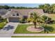 Charming one-story home featuring a well-manicured lawn with a palm tree and a classic two-car garage at 1049 Larkin Rd, Spring Hill, FL 34608