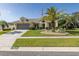 Delightful one-story home featuring a lush lawn, a decorative palm tree, and a practical two-car garage at 1049 Larkin Rd, Spring Hill, FL 34608