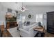 Bright living room featuring a ceiling fan, fireplace, and decor elements on shelving at 1049 Larkin Rd, Spring Hill, FL 34608