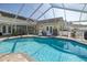 Screened-in pool with lounge chairs, outdoor dining space, and access to the backyard at 1049 Larkin Rd, Spring Hill, FL 34608