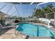 Sparkling private pool with a covered lanai, poolside seating and manicured landscaping at 1049 Larkin Rd, Spring Hill, FL 34608