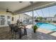 Covered outdoor dining area with table and chairs, overlooking the screened-in pool area at 1049 Larkin Rd, Spring Hill, FL 34608