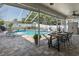 Outdoor dining space features a table and chairs, with relaxing lounge chairs beside the pool at 1049 Larkin Rd, Spring Hill, FL 34608