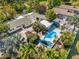 Aerial view showcases a swimming pool, tropical landscaping, and backyard oasis at 1115 Pennsylvania Ave, Palm Harbor, FL 34683
