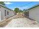 Backyard area with concrete patio, white siding, and green trim, offering ample space for outdoor activities at 1115 Pennsylvania Ave, Palm Harbor, FL 34683