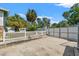 White picket fence and gate lead to the backyard oasis with lush landscaping and privacy at 1115 Pennsylvania Ave, Palm Harbor, FL 34683