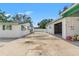 Spacious backyard featuring a house and detached garage with an open bay and access gate at 1115 Pennsylvania Ave, Palm Harbor, FL 34683