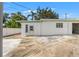 Exterior of a white building with a green trim, a concrete patio and blue sky background at 1115 Pennsylvania Ave, Palm Harbor, FL 34683